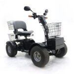 Black four-wheeled electric mobility scooter with wide tires, a cushioned seat, rear and front wire baskets, and handlebar mirrors, designed for all-terrain use