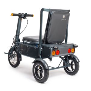 The image displays the eFOLDi Mobility Scooter from a rear three-quarter perspective. The scooter is predominantly dark-colored with a sturdy frame and features a comfortable, cushioned seat with a high backrest that has the eFOLDi logo on it. It has a three-wheel design with chunky, durable tires, two at the rear and one at the front, suggesting good stability and traction. The rear of the scooter is equipped with a set of lights, including orange turn signals and red brake lights, which enhance its visibility and safety on the road. The handlebar setup includes handgrips and various control mechanisms. The design indicates that the scooter is built for both comfort and practicality, with a focus on outdoor mobility.