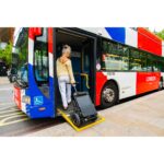 The eFOLDi Lite scooter boarding a public bus via a ramp, showcasing the scooter's compatibility with public transportation and the rider's ability to travel seamlessly around the city.