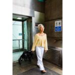 A woman exiting an elevator while pulling the eFOLDi Lite scooter in its folded position, emphasizing the ease with which the scooter can be taken into buildings and public transport.
