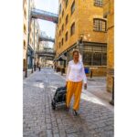 A smiling individual walking alongside the folded eFOLDi Explorer scooter, emphasizing the scooter's compact size and ease of manual transport.