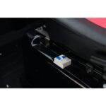 Detail of the master power switch located under the seat of a Green Transporter Q Express, showcasing the switch's label and connector.