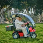 Live Style Image Side View of Red Afiscooter S3 Dual Seat Mobility Scooter with Canopy Golf Tires