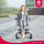 Girl smiling while sitting on Bangeran Pegasus lightweight folding power chair outdoors.