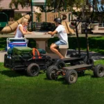 Family relaxing at park with CycleBoard X-Quad 3000 electric scooters and cargo trailer